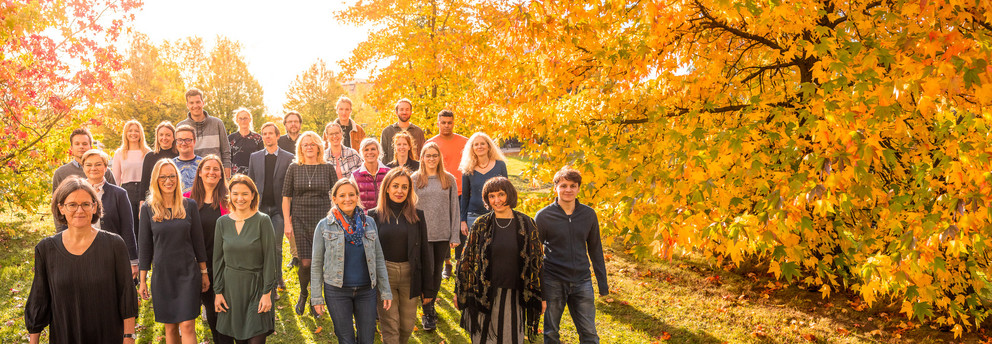Die Mitglieder des Instituts für Diversitätsstudien (September 2021) laufen über eine Wiese auf dem Campus der TU Dortmund
